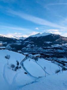 una colina cubierta de nieve con montañas en el fondo en Egghof en Prato allo Stelvio