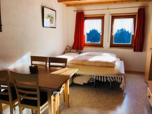 a bedroom with a bed and a table and chairs at Egghof in Prato allo Stelvio