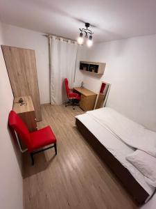 1 dormitorio con cama, silla y escritorio en Bright Rooms, en Cracovia