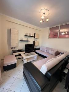 ein Wohnzimmer mit einem Sofa und einem Tisch in der Unterkunft Melina Apartment by Elite Inn in Vlorë
