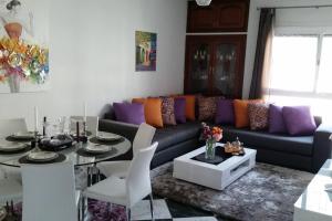 una sala de estar con un sofá y una mesa en Tétouan Martil Spacieux 2CH 2SDB Confort Parking Gratuit & WIFI FIBRE OPTIQUE!!!, en Tetuán