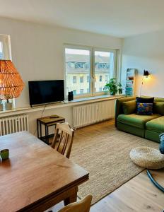 a living room with a green couch and a table at FeelsLikeHome - Wunderschöne und zentrale Wohnung mit Balkon&Parkplatz in Bochum