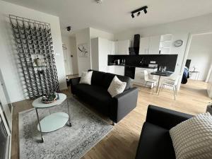 a living room with a black couch and a table at Tor nach Hannover in Springe