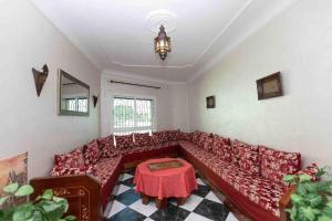 ein Wohnzimmer mit einem roten Sofa und einem Tisch in der Unterkunft Appartement Tetouan Saniat Ramel Airport Plage Martil WIFI in Tétouan