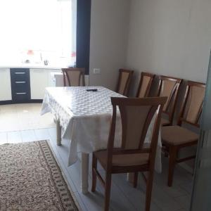 a dining room with a white table and chairs at Hostel Sebzor in Tashkent
