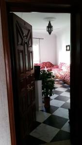 a door leading to a room with a checkerboard floor at Appartement Tetouan Saniat Ramel Airport Plage Martil WIFI in Tetouan