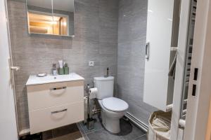 a bathroom with a white toilet and a sink at Cours de Vincennes Suite PARIS 12 in Paris