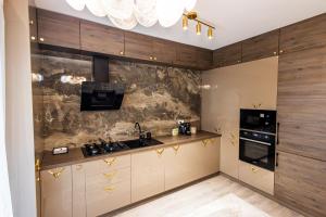 a kitchen with a sink and a stove top oven at Maieru’s Apartament Dumbravita in Dumbrăviţa