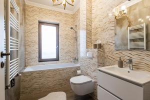 La salle de bains est pourvue de toilettes, d'une baignoire et d'un lavabo. dans l'établissement Maieru’s Apartament Dumbravita, à Uisenteş