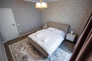 a small bedroom with a bed with white sheets at Maieru’s Apartament Dumbravita in Dumbrăviţa +10 photos