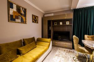 a living room with a yellow couch and a table at Maieru’s Apartament Dumbravita in Dumbrăviţa