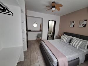 a bedroom with a bed and a ceiling fan at Villa kontes kefalonia in Kardhakáta