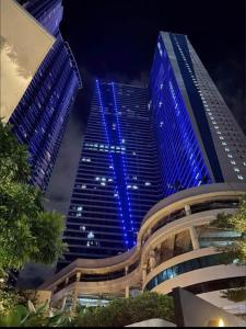 un edificio alto con luces azules por la noche en Air Residences in the Heart of Makati City - Great for Tourists, Staycations or Working Professionals, en Manila
