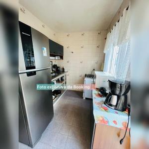 a kitchen with a stainless steel refrigerator and a counter at casa de praia ibicui in Mangaratiba