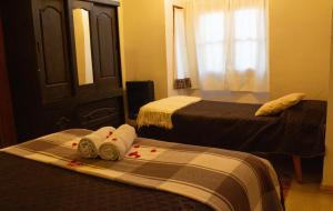 1 dormitorio con 2 camas, toallas y ventana en La Carmela, en Esquel