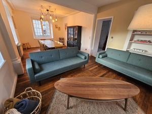 a living room with two blue couches and a table at Maison Le Beauregard Bussang in Bussang