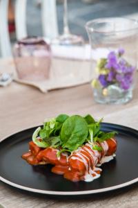 a black plate with food on a table at La Maison Rosa Stella in Lucera