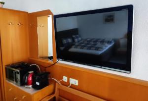 a large television hanging on a wall in a room at Duplex apartment Almberg in Philippsreut