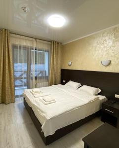 ein Schlafzimmer mit einem großen Bett und einem Fenster in der Unterkunft Villa For You Hotel in Poljanyzja