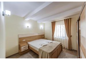 una camera da letto con un letto e una finestra di Luxury Apartment a Piteşti