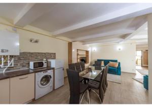 una cucina e un soggiorno con tavolo e sedie di Luxury Apartment a Piteşti