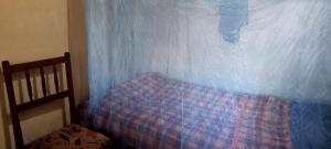 a bedroom with a bed and a blue curtain at Qyani Country Side Stay in Migori