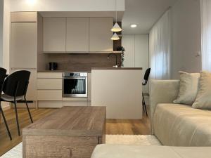 a kitchen and living room with a couch and a table at City Luxe Apartment in Čakovec