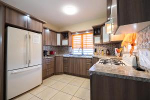 uma cozinha com armários de madeira e um frigorífico branco em Arenales Vacational House em Isabela