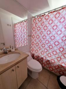 uma casa de banho com um WC e uma cortina de chuveiro em Departamento Frente Playa las Torpederas em Valparaíso