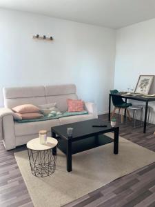 - un salon avec un canapé et une table dans l'établissement Appartement confortable aux portes de Paris, à Charenton-le-Pont