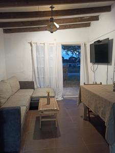 sala de estar con sofá, TV y mesa en Renapau2D, en La Paloma