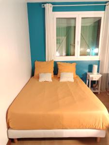 a bed with two pillows in a room with a window at Chambres avec piscine in Toulouse