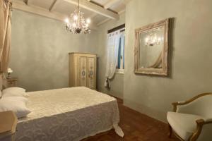 een slaapkamer met een bed, een spiegel en een stoel bij Casa Bartoli - Panoramic House Buggiano Castello in Borgo a Buggiano