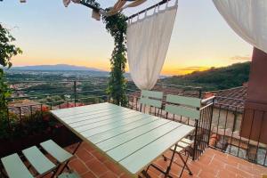 een tafel en stoelen op een balkon met uitzicht bij Casa Bartoli - Panoramic House Buggiano Castello in Borgo a Buggiano