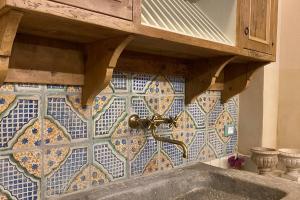 eine geflieste Wand mit einem Wasserhahn auf einem Waschbecken in der Unterkunft Casa Bartoli - Panoramic House Buggiano Castello in Borgo a Buggiano