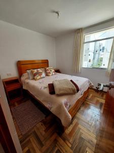 a bedroom with a bed and a large window at Mandalas Cusco in Cusco