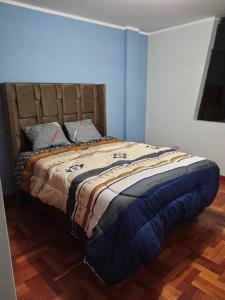 Cama en habitación con pared azul en Departamento Cielo Cajamarquino, en Cajamarca