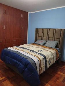 1 dormitorio con 1 cama y armarios de madera en Departamento Cielo Cajamarquino, en Cajamarca
