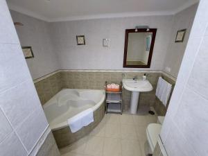 a bathroom with a tub and a sink at CASA JARO in Sierra de Yeguas +37 photos