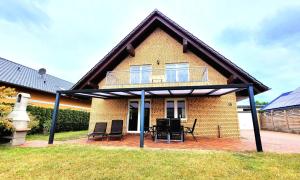 a house with a roof with chairs and a patio at Ferienwohnung am Plauer See - a55900 in Alt Schwerin