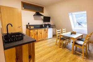 a kitchen and dining room with a table and a kitchen with a sink at Apartmaji pri Dravi in Podvelka
