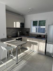 una cocina con mesa y sillas. en La villa des Lauriers, en Montélimar