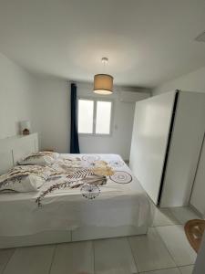 Una cama blanca en una habitación con ventana. en La villa des Lauriers, en Montélimar