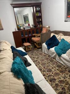 una sala de estar con 2 sofás con almohadas azules. en come to me, en Cali