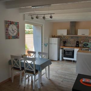 a kitchen and dining room with a table and chairs at La Demoiselle du Finistère in Plobannalec-Lesconil