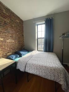 sypialnia z łóżkiem i ceglaną ścianą w obiekcie Breathtaking 3 Bedroom apartment in NYC! w Nowym Jorku