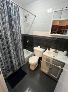 a bathroom with a toilet and a sink at Breathtaking 3 Bedroom apartment in NYC! in New York