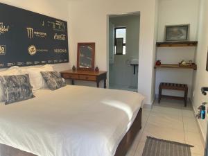 a bedroom with a large white bed in a room at Aloe Studio in Jeffreys Bay