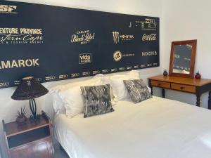a bedroom with a bed and a wall with a giants sign at Aloe Studio in Jeffreys Bay +4 photos