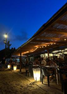 un gruppo di persone seduti ai tavoli sotto un pergolato di Acogedor apartamento con vistas 80 m2 ad Alcossebre